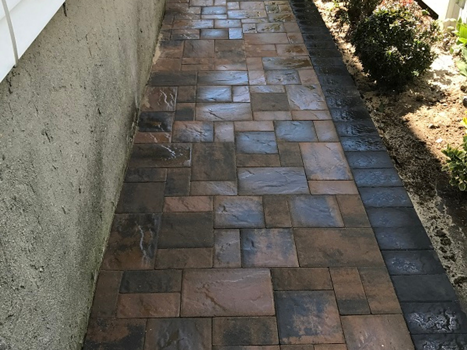 Belgian block bordered paver walkway between houses