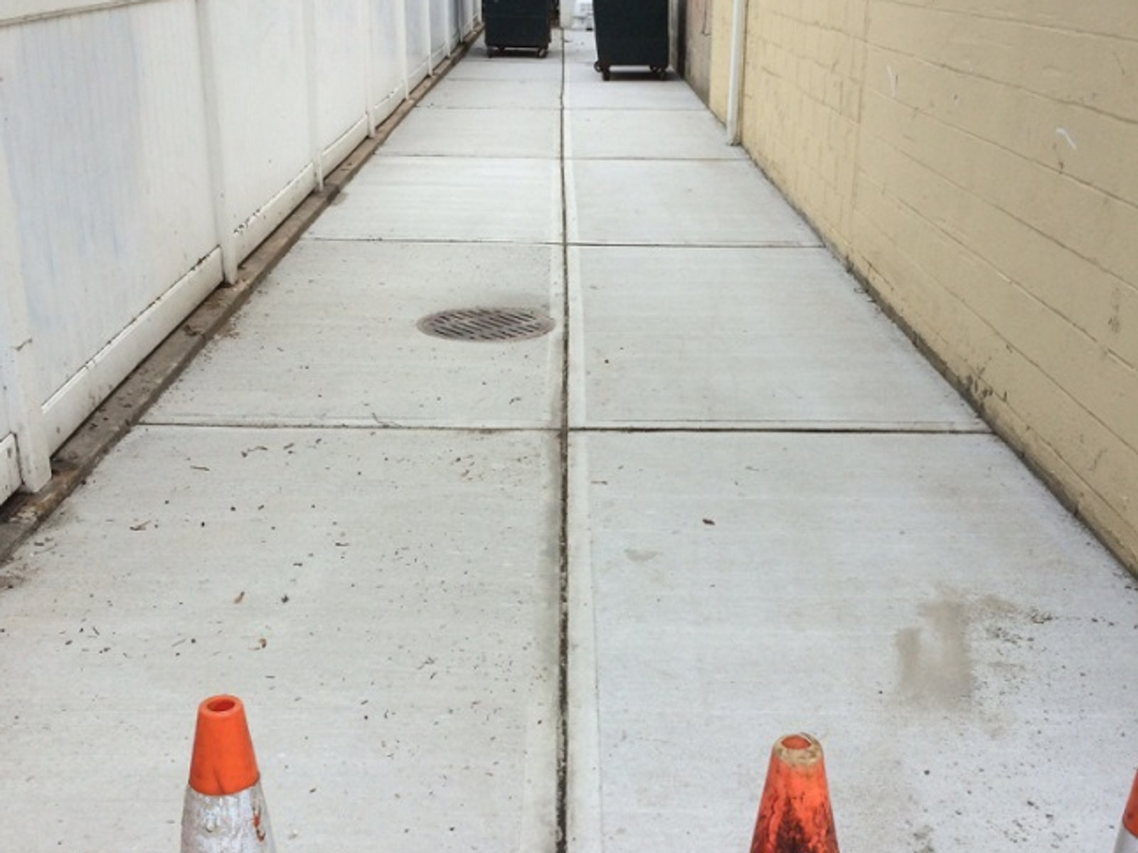 Concrete sidewalk expansion with cones marking the pour