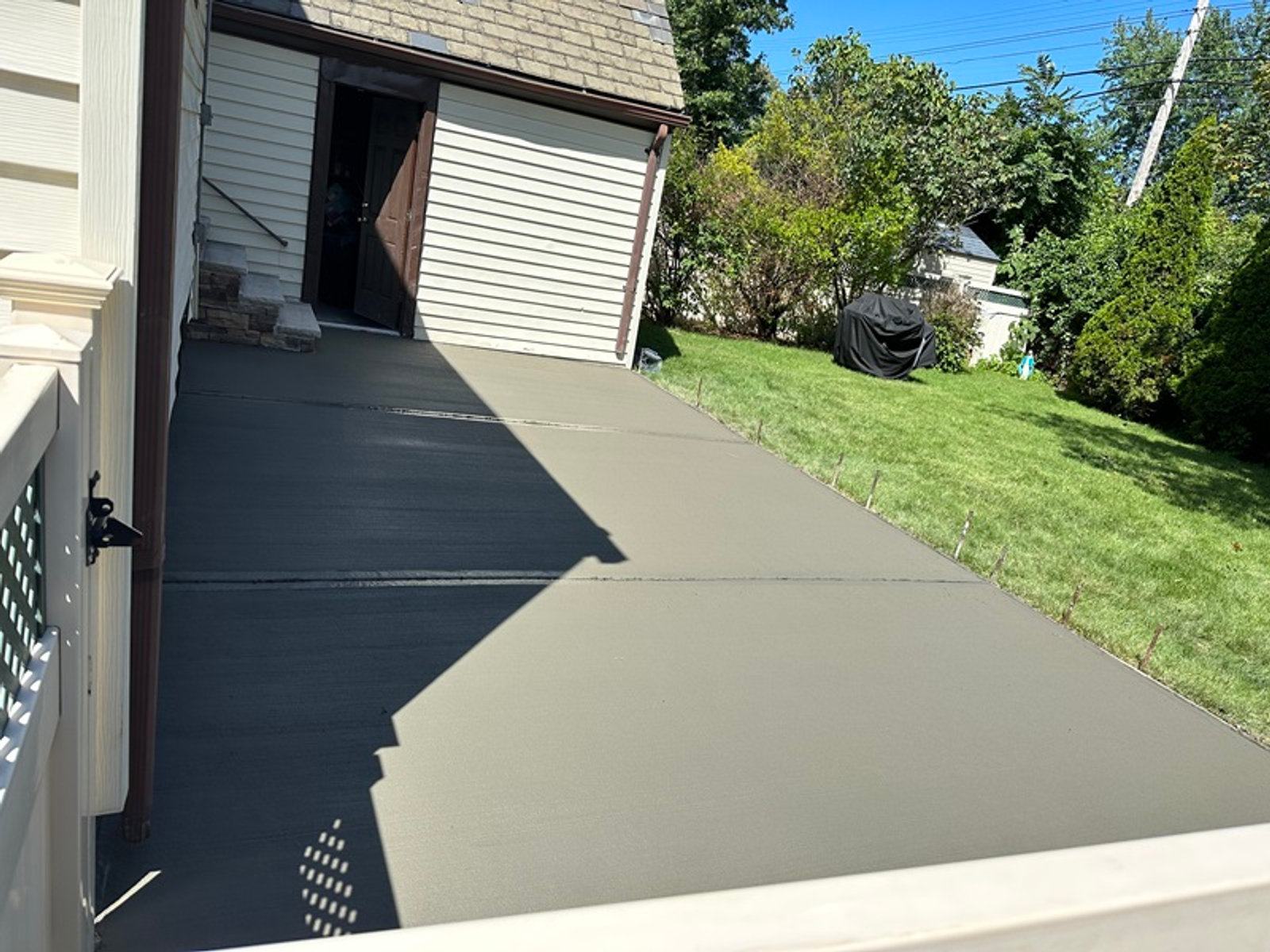 Broom-finished concrete driveway alongside a Long Island home